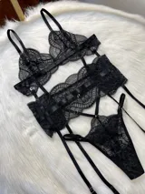 Conjunto de lencería de cuatro piezas en encaje negro. Incluye bralette con breteles regulables, tanga con tiras dobles ajustables en la cintura, portaligas con enganches desmontables y ligas para las piernas.