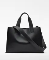 Bolso shopper horizontal negro de piel sintética, con dos compartimentos, cierre magnético y bolsillo interior con cremallera. Cuenta con asa de mano y correa larga regulable y extraíble, además del logo grabado en el frente.