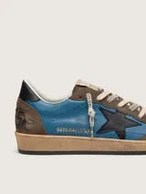 Zapatillas Golden Goose modelo Ball Star de estilo retro, combinando cuero liso azul con detalles de gamuza marrón, estrella lateral negra y suela con efecto envejecido.