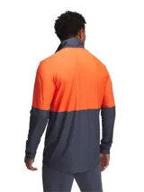 Campera deportiva Under Armour de la línea Challenger, con cierre frontal completo y cuello alto. Presenta un diseño bicolor en gris y naranja, con el logo de la marca estampado en el pecho. Cuenta con tejido de punto ligero, resistente y transpirable que absorbe el sudor.