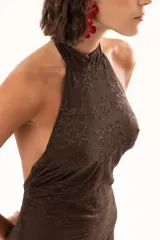 Vestido largo de encaje color chocolate, con escote halter y diseño ajustado en el torso que se abre en una falda con transparencia en el ruedo.
