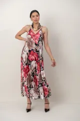 Solera de seda plisada con tirantes finos y escote en V, con estampa floral en tonos rojo, negro y blanco, de corte amplio y largo midi.