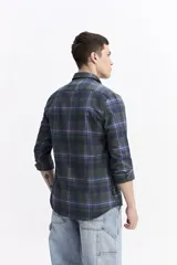 Camisa de manga larga confeccionada en viyela de algodón con diseño de cuadros en tonos azul y verde. Presenta cierre frontal con botones, cuello clásico y bolsillo en el pecho.