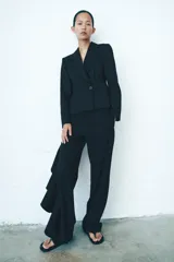 Blazer entallada de Zara, confeccionada en hilatura con lana. Presenta cuello solapa de muescas, manga larga con botones en puños, bolsillos de vivo en el delantero y cierre frontal cruzado con botones.