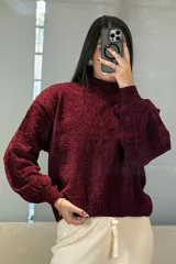 Buzo de chenille color marrón, con cuello alto, mangas largas con puños ajustados y ruedo acanalado.
