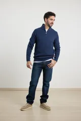 Sweater verde de punto inglés con cuello alto y cierre metálico frontal. Tiene mangas largas y terminaciones en punto canalé.