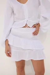 Minifalda azul de lino con dos volados superpuestos, terminación de encaje en los bordes.