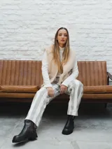 Chaleco color crema con textura de piel sintética, sin mangas y con forro interno.