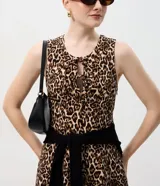 Vestido corto de corte evasé con estampado animal print, escote redondo y detalle de abertura frontal con lazos. Confeccionado en tejido de bengalina con viscosa, poliamida y elastano.