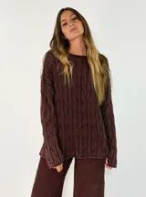 Sweater de punto con diseño de trenzas verticales, cuello redondo y corte holgado. Presenta un acabado texturizado con efecto lavado en color gris oscuro.