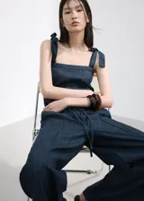 Pantalón de mezclilla azul oscuro, con silueta wide leg, tiro alto y pretina con cordón ajustable.