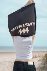 Buzo negro de corte amplio con estampado frontal de la marca 'Classy Waves' en color blanco. Es de mangas largas y cuello redondo. Es reversible y se puede usar de ambos lados.