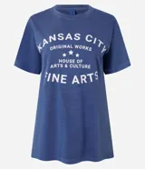 Remera azul de algodón con cuello redondo y mangas cortas. Estampado frontal con la leyenda "Kansas City Original Works House of Arts & Culture Fine Arts" en letras blancas.