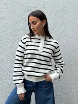 Sweater de punto a rayas horizontales blancas y negras, con cuello redondo, cierre frontal con botones y detalles de puntilla en el cuello y los puños.
