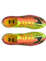 Championes de fútbol Under Armour Shadow Elite 4 Mach FG, en tonos rojo, negro y amarillo flúor. Presentan un diseño aerodinámico con empeine texturizado, cuello elástico de punto, cordones integrados y tapones cónicos en la suela.