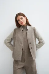 Chaqueta corta color marrón con cuello solapa y diseño con patchwork de telas. Manga larga con detalle de coderas aplicadas. Cierre frontal mediante botones y bolsillos ojal. Con forro.