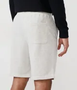 Bermuda deportiva negra con cintura elástica ajustable con cordón, bolsillos laterales y corte a la rodilla.