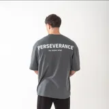 Remera de corte oversize color gris oscuro con estampado tipográfico en la espalda que incluye la palabra Perseverance y la frase No matter what.