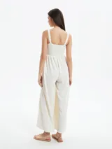Monoprenda larga color blanco off white, con escote cuadrado y cuerpo estilo nido de abeja elástico. Presenta tirantes anchos y perneras amplias y sueltas.