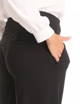 Pantalón de vestir color marrón, de corte wide leg y tiro alto. Presenta una cintura ancha con detalles de hebillas y botones decorativos en tono dorado, además de bolsillos laterales funcionales.