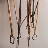 Collar doble con cadena de cuero sintético negro y dije rectangular plateado.