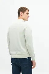 Buzo azul marino de tejido de punto con cuello alto y medio cierre con cremallera.