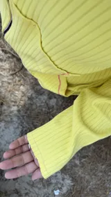 Campera de algodón premium color amarillo con cuello, puños y dobladillo en marrón. Tiene cierre frontal, bolsillos delanteros con ribetes rosados y la letra 'K' bordada en rosa en el pecho.