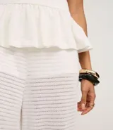 Pantalón estilo aladín blanco, de tejido piqué texturizado, con cintura elástica y puños ajustados en los tobillos.