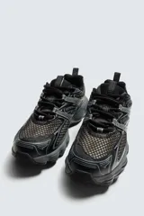 Zapatilla deportiva tipo running color blanco hueso con detalles en azul marino y amarillo flúor.