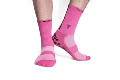 Medias deportivas de caña media color fucsia, con suela antideslizante de puntos negros y logo de la marca estampado en la parte superior.