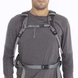 Mochila de trekking Merrell modelo Grayling de 30 litros, color negro con detalles en naranja vibrante en cierres y cordones. Presenta un logo 'M' en naranja en la parte superior y la marca 'MERRELL' en naranja en el bolsillo frontal inferior.