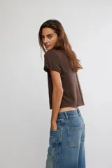 Remera de jersey suave color negro, de calce relajado, corte recto y largo corto, con escote en V y mangas cortas caídas con puño fijado.