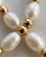 Collar de acero con baño de oro, compuesto por una alternancia de perlas de río y pequeñas cuentas doradas.
