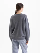 Sweater de lana gris con silueta holgada y cuello redondo. Presenta un bordado frontal colorido con motivos de esquí y la inscripción 'Apres Ski'.