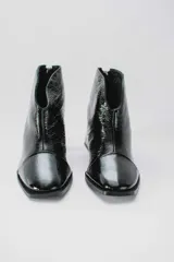 Botinetas de cuero charolado color negro, con taco cuadrado de 6,5 cm, punta cuadrada y diseño de corte en V en el empeine.