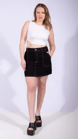 Minifalda negra de jean con costuras blancas contrastantes y bolsillos delanteros y traseros.