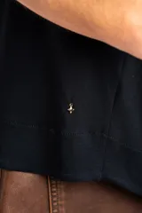 Remera negra de corte oversize, con mangas cortas y cuello redondo, confeccionada en tejido de viscosa y elastano de caída fluida.