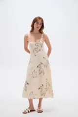 Vestido midi de viscosa color beige con estampado de hojas en tonos verdosos, de corte holgado, con tirantes finos regulables y escote cuadrado.