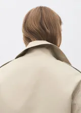 Chaqueta crop de doble botonadura color beige, con cuello pico con solapa, mangas largas y dos bolsillos laterales.