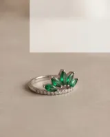 Anillo de plata 925 con diseño de corona adornado con piedras naturales verdes talladas en formato marquise y detalles de circón pavé en la banda.