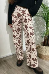 Pantalón de jean color beige con estampado de manchas marrones tipo vaca, de corte wide leg y tiro medio.