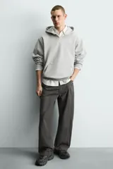 Zapatilla deportiva de estilo running, completamente negra, con capellada de malla y superposiciones sintéticas. Presenta una suela gruesa y voluminosa con diseño segmentado.