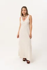 Vestido largo color beige de lino imperial, con escote en V, espalda con tirantes anchos y bordados en la parte superior. Tiene tajos a ambos lados.