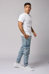Pantalón jean celeste, corte jogger, con bolsillos cargo laterales y puños elásticos en los tobillos.