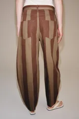 Jeans de tiro alto con diseño tapered y cinco bolsillos, con estampado de rayas verticales a contraste en tonos marrón y tostado. Cierre frontal con cremallera y botón.