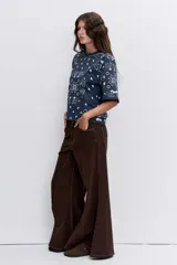 Remera de corte oversize color marrón con estampado tipo bandana en color blanco. Presenta cuello redondo y mangas cortas amplias.