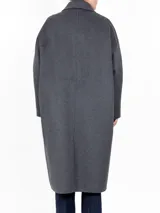 Tapado de corte largo hasta la rodilla, con cierre frontal de botones, cuello clásico, bolsillos laterales y puños con detalle de botón. Diseño estructurado y elegante.