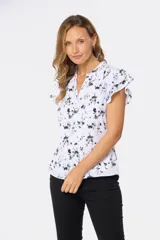 Blusa blanca con estampado floral negro, escote en V y mangas cortas con volados.