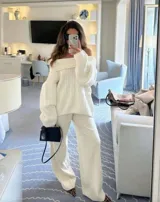 Buzo tejido de punto color crudo con diseño off-shoulder, textura acanalada y calce relajado.