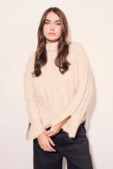 Sweater color crema con cuello alto, tejido de punto con textura y mangas largas con puños acampanados.